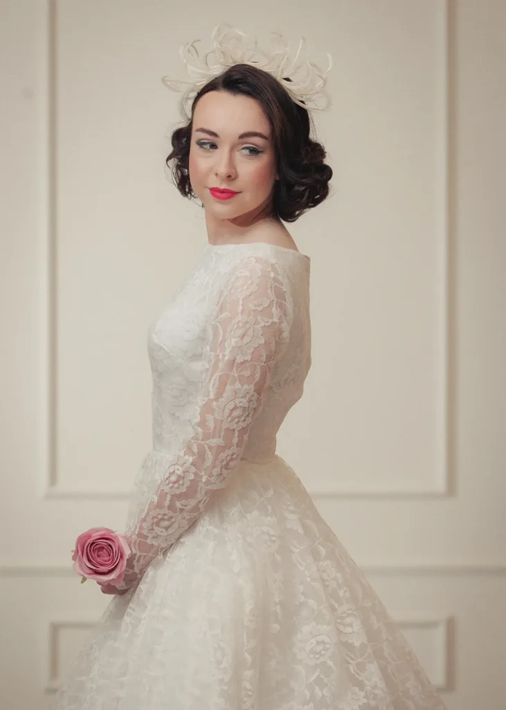 Bride wearing a vintage lace dress with a white feathered headband.