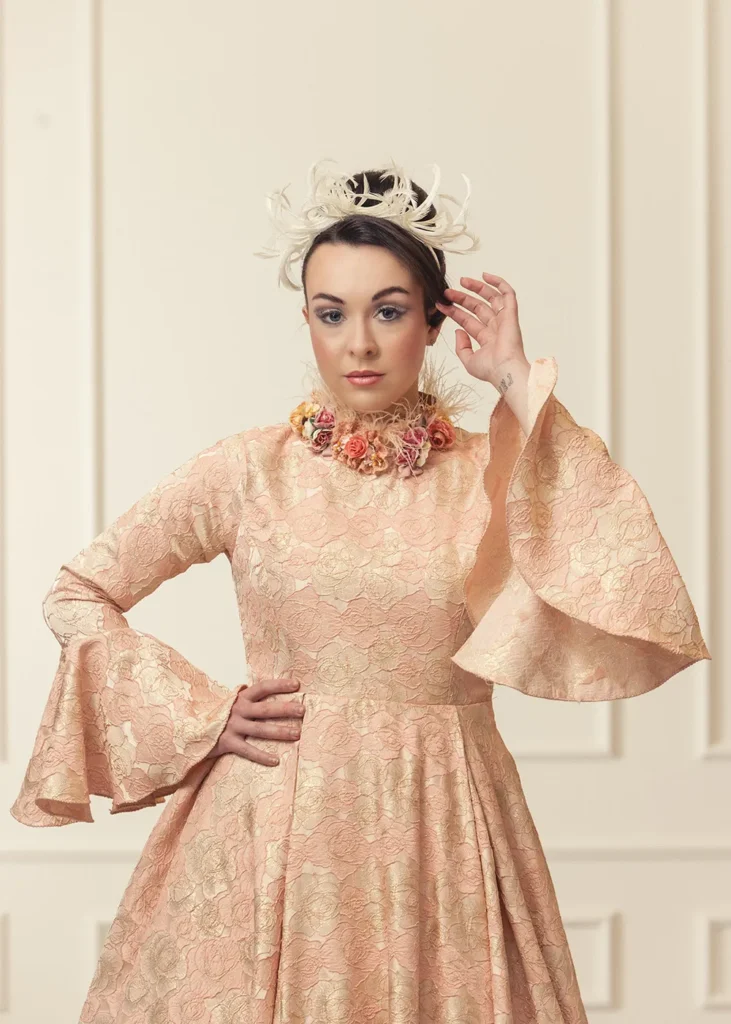 Bride wearing a peach-coloured vintage wedding dress with a feather headpiece.